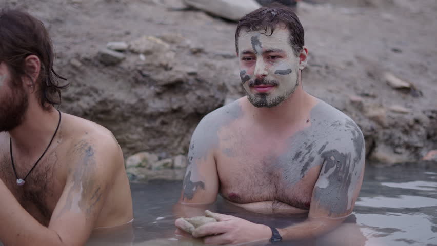 Bearded boy with a muddy face looking at his friends side