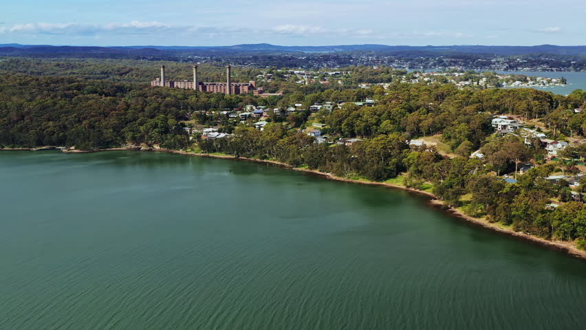 Aerial view flying towards the lakeshore with the power station in the distance.