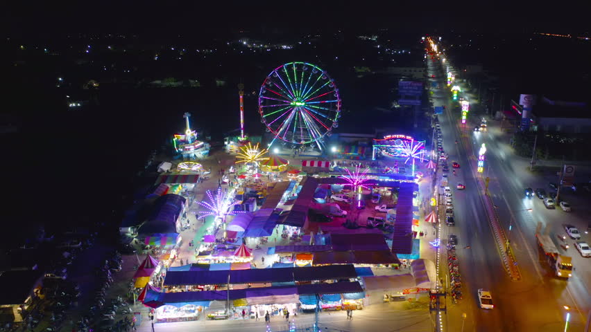 Aerial top view of amusement park in night temple fair, and night local markets. People walking street, Colorful tents in Bangkok city, Thailand. Retail shops