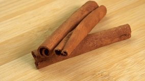 Cinnamon sticks rotate on a wooden background. Fragrant cinnamon seasoning close-up. Spices with cinnamon. Food cooking video concept. ingredients for warm wine, mulled wine