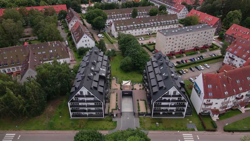 Residential complex in small town, aerial view. Living houses with parked cars near green park