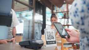Close up of customer's hand scanning QR code to pay for coffee in cafe. Attractive young woman use smartphone make a quick and easy contactless payment for service to barista or waiter in coffeehouse. - Powered by Shutterstock - Get 15% off with code: PIKWIZARD15