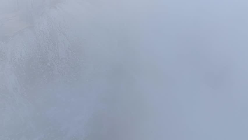 Drone flight through dense clouds showing hiker path in Dolomite mountains - revealing shot
