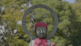 This video shows an outdoor buddhist deity statue with children at it's feet.