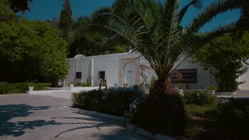 Shot of a male walking towards old white door of building. Tourist admiring the surroundings of visited country.