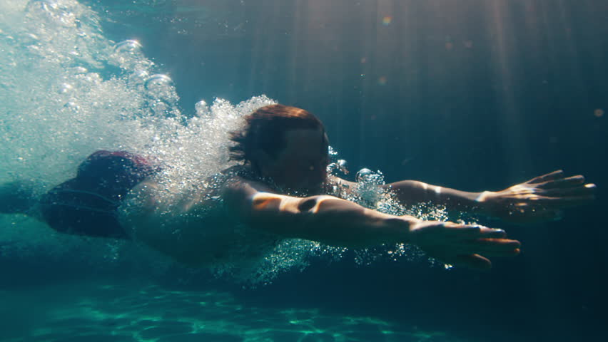 Man dives in the pool. Underwater view of the person diving in the pool and gliding underwater with bubbles | Shutterstock HD Video #1098087279