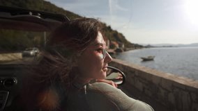 Beautiful girl have fun riding in convertible cabriolet car wearing heart-shaped glasses, freedom concept when hair fluttering in the wind. Summer Vacation at sea, in the mountains, on the coast. Car - Powered by Shutterstock - Get 15% off with code: PIKWIZARD15