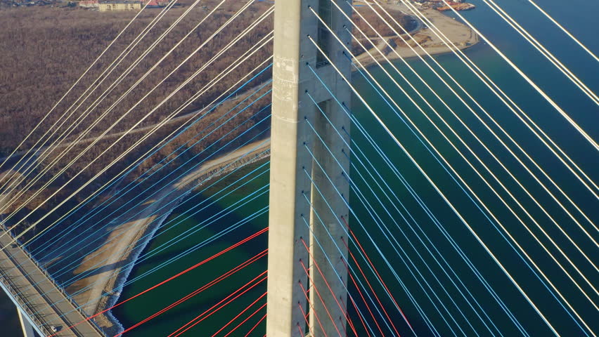 Aerial view of the Russian bridge over the Eastern Bosphorus strait in Vladivostok. Cars driving on the roadway of the cable-stayed bridge Royalty-Free Stock Footage #1098093889