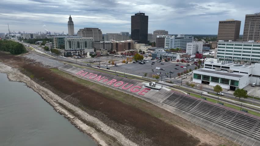 Baton Rouge sign by riverbank of Mississippi River. Mississippi state capitol and downtown district. Aerial view.