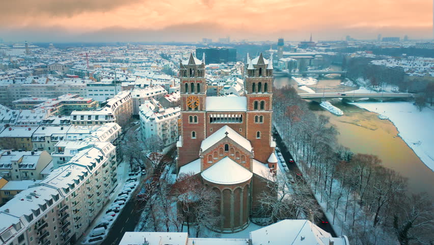 Winter Munich skyline aerial view of St. Maximilian is a Roman Catholic parish church of the Isar suburb in Munich, southern Germany. Munich winter snow skyline aerial view isar river church downtown. Royalty-Free Stock Footage #1098100301