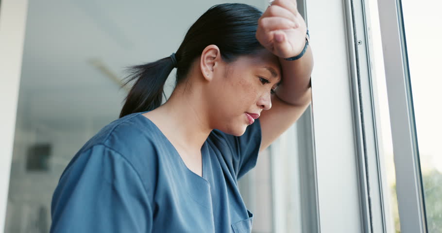 Healthcare nurse, stress and headache by window for working burnout, frustrated employee and tired asian woman in hospital. Doctor, pain and sad medical worker, anxiety or mental health depression Royalty-Free Stock Footage #1098105231