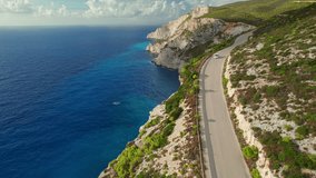 Aerial view of a car on a beautiful coast road with high cliffs and turquoise sea water on Zakynthos island, Greece. Travel destination of the Zante island in Greece. Drone footage