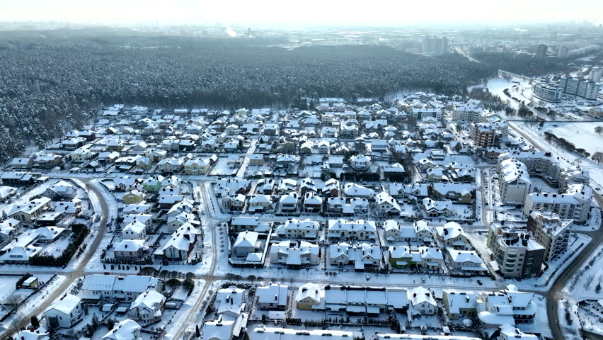 Cottages in winter snow. Houses in Residential community in snowscape. House in Town after winter snowstorm. Snow covered rooftops of townhouse, Aerial. Suburb house in in winter time. Snowy street.