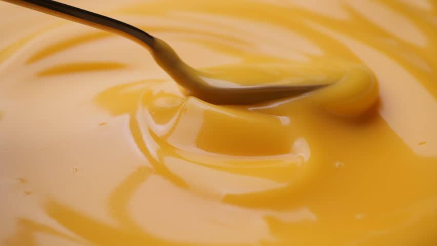 Stirring yellow cheese sauce with golden spoon Royalty-Free Stock Footage #1098117143