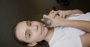 The concept of raising children in love with animals - a girl with a domestic rat. Vertical video. Close-up 4k footage.