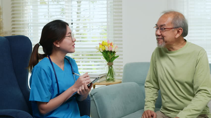 Asian young nurse writing prescription during home visit sick elder old man, Senior man takes doctor at home telling about health complaints, health care and medical concept