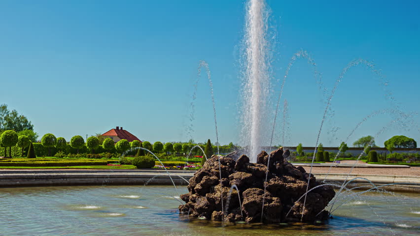 Water flowing of majestic fountain on sunny day, fusion time lapse