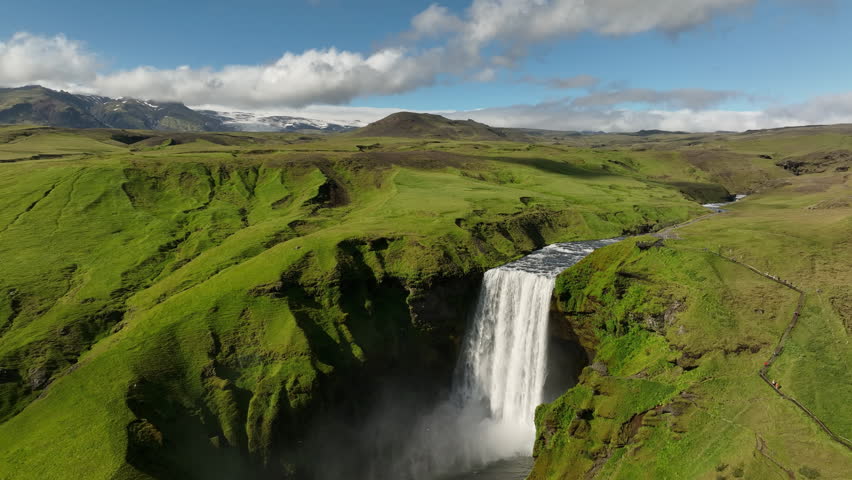 waterfall in the mountains of Iceland volcanic glacier in background aerial sunny day Royalty-Free Stock Footage #1098133127