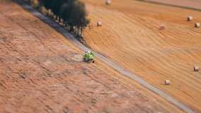 Tractor raking the hay. A tilt-shift video. 