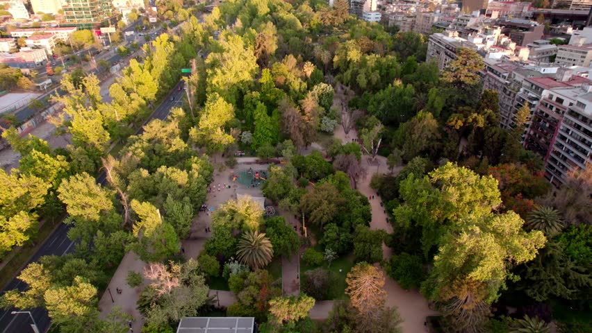Aerial view of the Parque Forestal with trees in spring and children playing, a recreational area in Santiago, Chile.