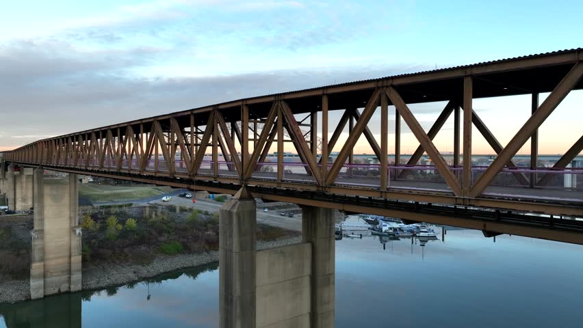 Mud Island State Park in Memphis Tennessee. Rising aerial reveals Hernando de Soto bridge over Mississippi River at sunrise.