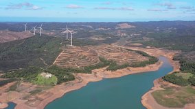 Aerial view. Video filming by drone over the dam and Bravura reservoir. Low levels of southern water supplies and lack of rain. Wind generators in the background.