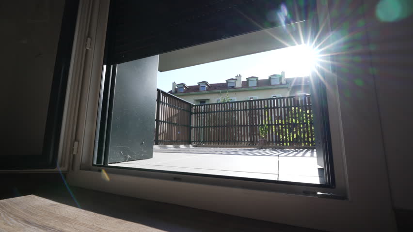 Opening electric blinds with lens flare sunlight shining. Low angle of smart motorized window. Wake up morning concept. Modern Automation