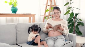 4K, Asian happy family, sitting on the sofa in room, There is father who walks in with orange juice to bring to your pregnant mother, lovely daughter is sitting next to her phone.
 - Powered by Shutterstock - Get 15% off with code: PIKWIZARD15