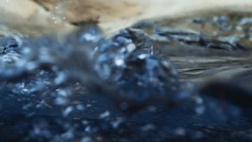 Slow motion video of water waves with splashes and falling drops. close up. split view. nature background. 4K