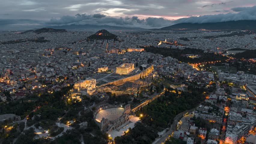 Aerial hyper lapse of illuminated Acropolis in Athens Greece seen during sunrise blue hour 