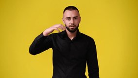4k slow motion video of one man looking at the camera over yellow background.