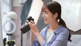 Female Asian photographer reviewing photo with camera - Powered by Shutterstock - Get 15% off with code: PIKWIZARD15