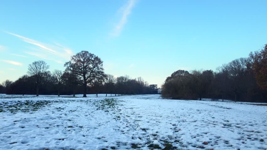 Grass field in countryside covered in white snow in winter in England