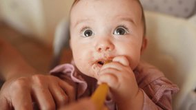 baby newborn eats. dirty mess baby girl eating vegetables. baby daughter eats on a feeding chair dirty face. naughty dirty babe indulges while feeding. happy kid indoors dream family weaning concept - Powered by Shutterstock - Get 15% off with code: PIKWIZARD15