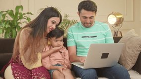 Happy smiling couple with sad kid using on laptop on sofa at home - concept of checking school admission or selection, seeing toys and ecommerce shopping.