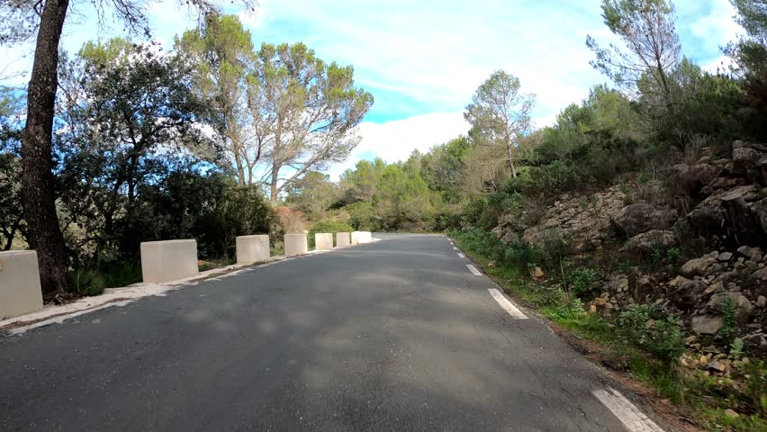 Silhouette of cyclist descending on empty mountain asphalt road at sunny day, pov shot. Professional road cyclist cycling on bicycle in mountains. Cycling training. Active sport concept