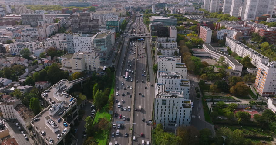 Cars are moving in heavy traffic on the bridge located in the capital of France. Rush hour traffic in the business district of Paris. Drone view of the urban set of cars Royalty-Free Stock Footage #1098197929
