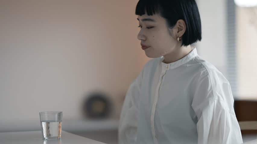 Young woman drinking water in calm room