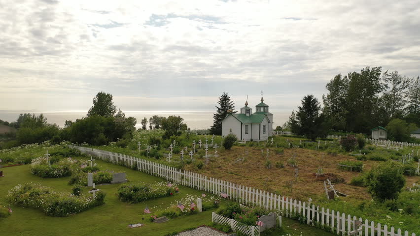 Aerial view of Russian Orthodox church, cemetery in a small distant settlement in North America. Ninilchik Village, Alaska, United States