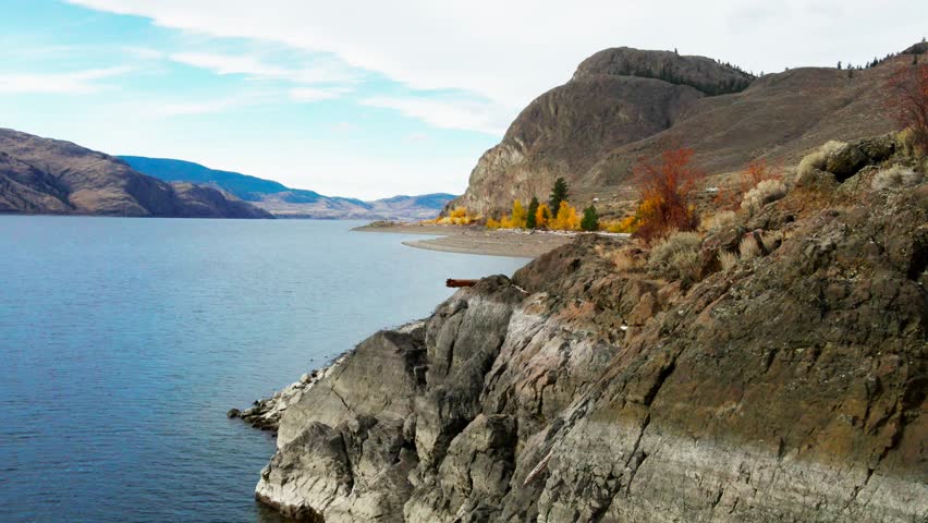 Approach Scene over the Bedrock Cliffs on the Shores of Kamloops Lake on a sunny day in the autumn, colourful picture of the Lake