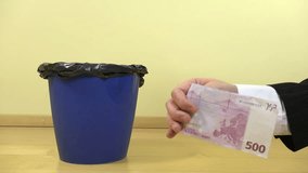 Businessman hand crumple five hundred 500 euro cash banknote and throw away in waste can bin. European currency money losing worth value. Crisis in Europe. Closeup shot. 4K UHD video clip.