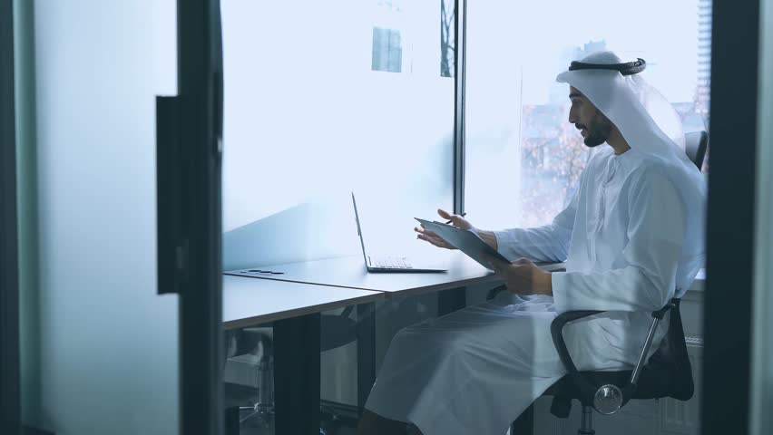handsome man with dish dasha working in his business office of Dubai. Portraits of a successful businessman in traditional emirates white dress. Concept about middle eastern cultures Royalty-Free Stock Footage #1098218379