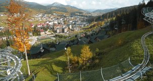 Alpine slide or rodelbahn in Bukovel - village and largest ski resort in Carpathian Mountains, Ivano-Frankivsk Oblast, western Ukraine. Cinema 4K 60fps video