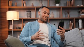 Friendly african american man having video call on smartphone. Close up serious guy making video chat online on mobile phone at home office. Focused businessman gesturing hands during conference call.