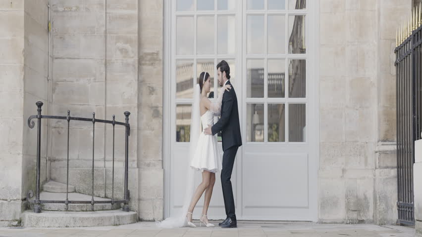 Beautiful date photo shoot. Action.A young girl in a short dress and a man lifting her and sitting in front of the architecture.