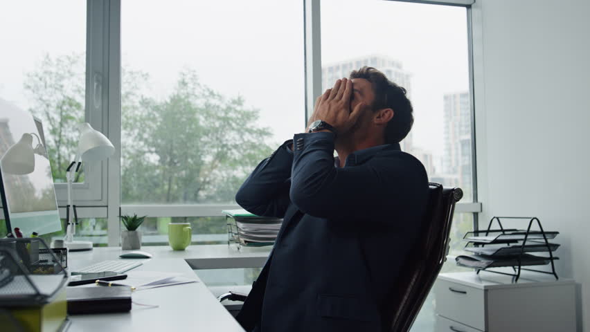 Upset man calling mobile at office workplace. Stressed manager thinking problems leaning chair. Frustrated businessman ponder financial personal issues covering face with hands. Work overload concept | Shutterstock HD Video #1098233239