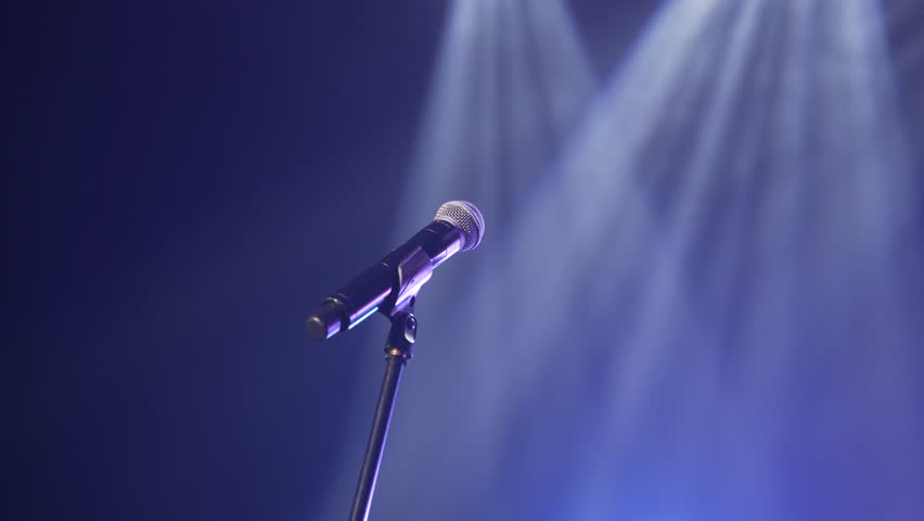 Microphone on stage on a black background. Concert microphone on stage in the dark. Microphone in smoke on a dark background. The concept of a musical instrument. Royalty-Free Stock Footage #1098238771