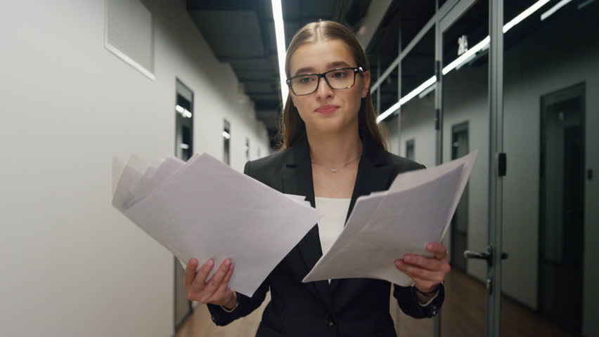 Stressed manager throwing papers in glass office. Upset woman walking hallway reading budget commerce report. Beautiful professional worker check mistake leaving workplace. Emotional burnout concept | Shutterstock HD Video #1098239195