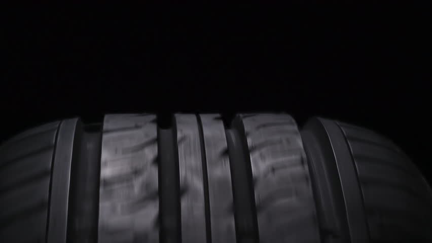 Heating Up Sports Tires. The spinning wheel rubs against the asphalt and creates a cloud of white smoke on a black background