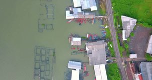 Overhead drone shot of Fisherman village on the lakeside with fish cages - Rawa Pening Lake, Indonesia